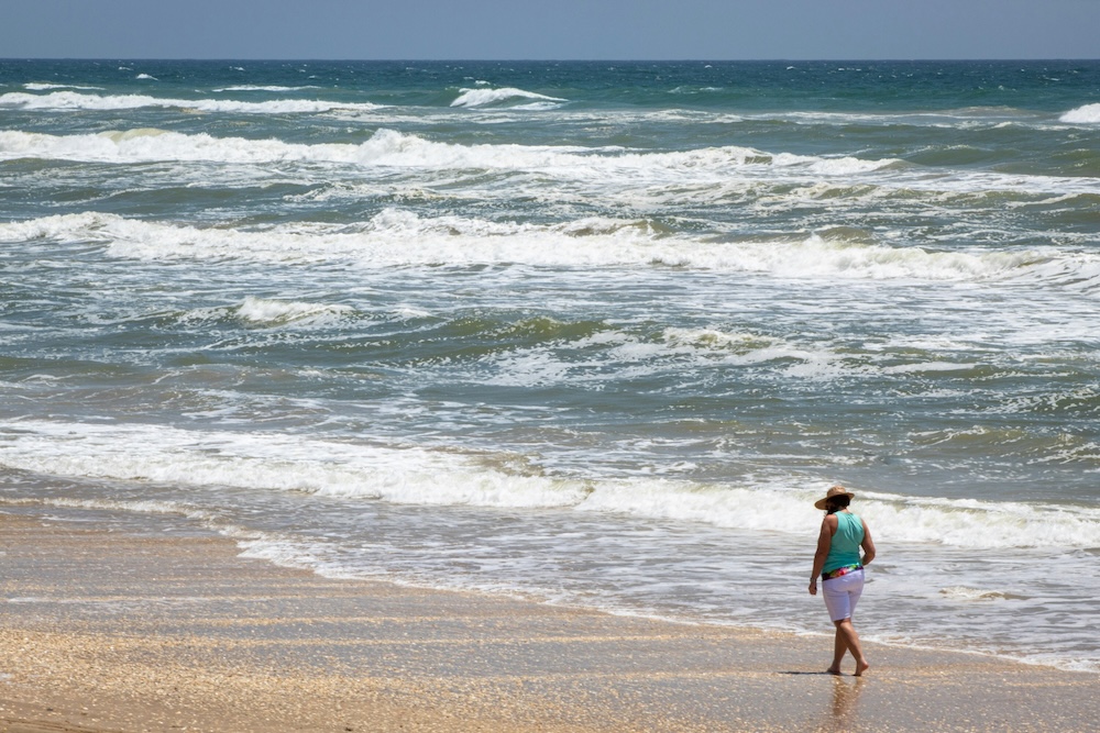 Woman walking on beach.